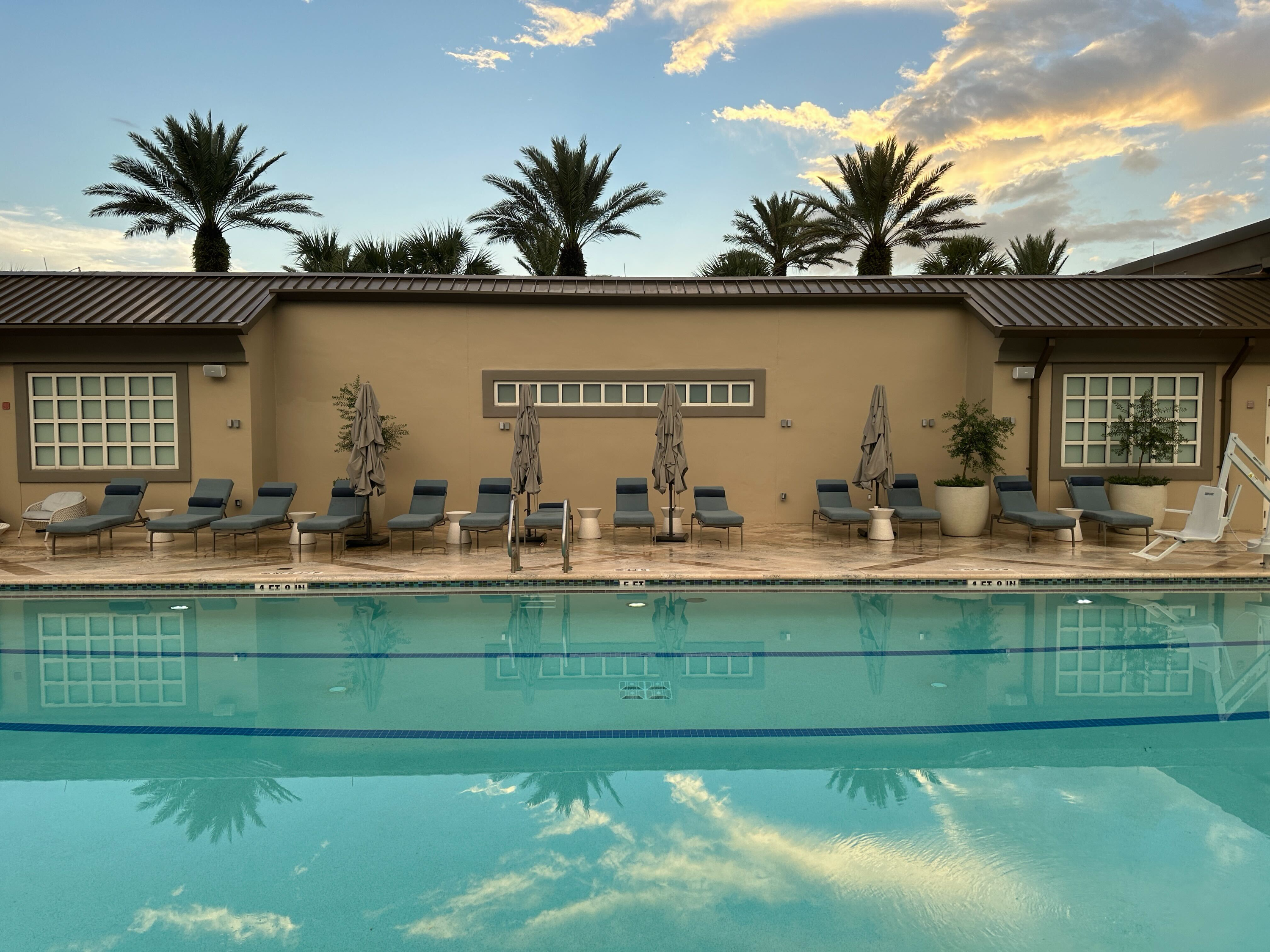 Resort pool deck — lounge chairs under golden sky