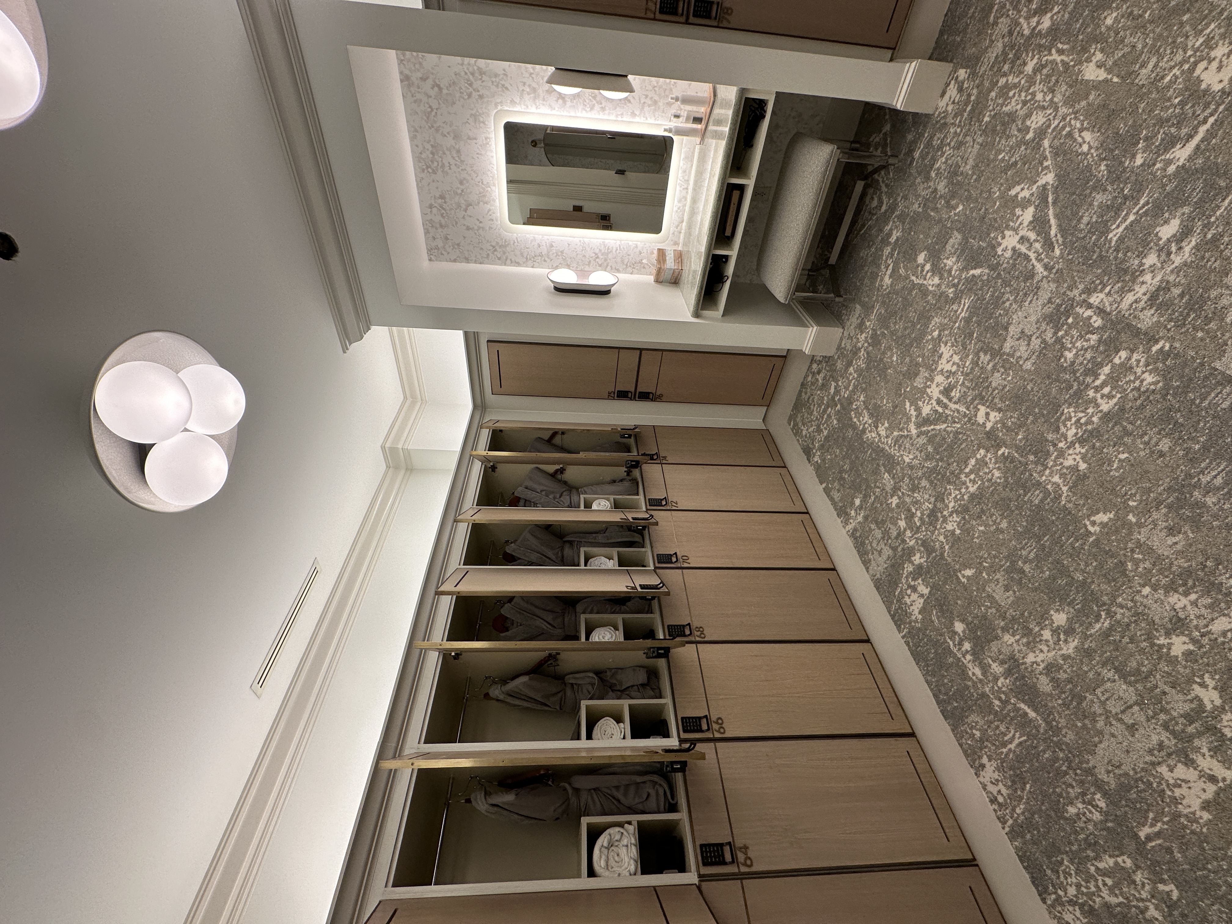 Spa locker room with warm wood lockers and vanity